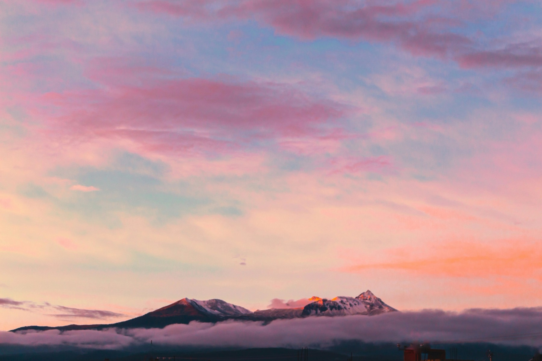 Pink clouds over a mountain at sunset