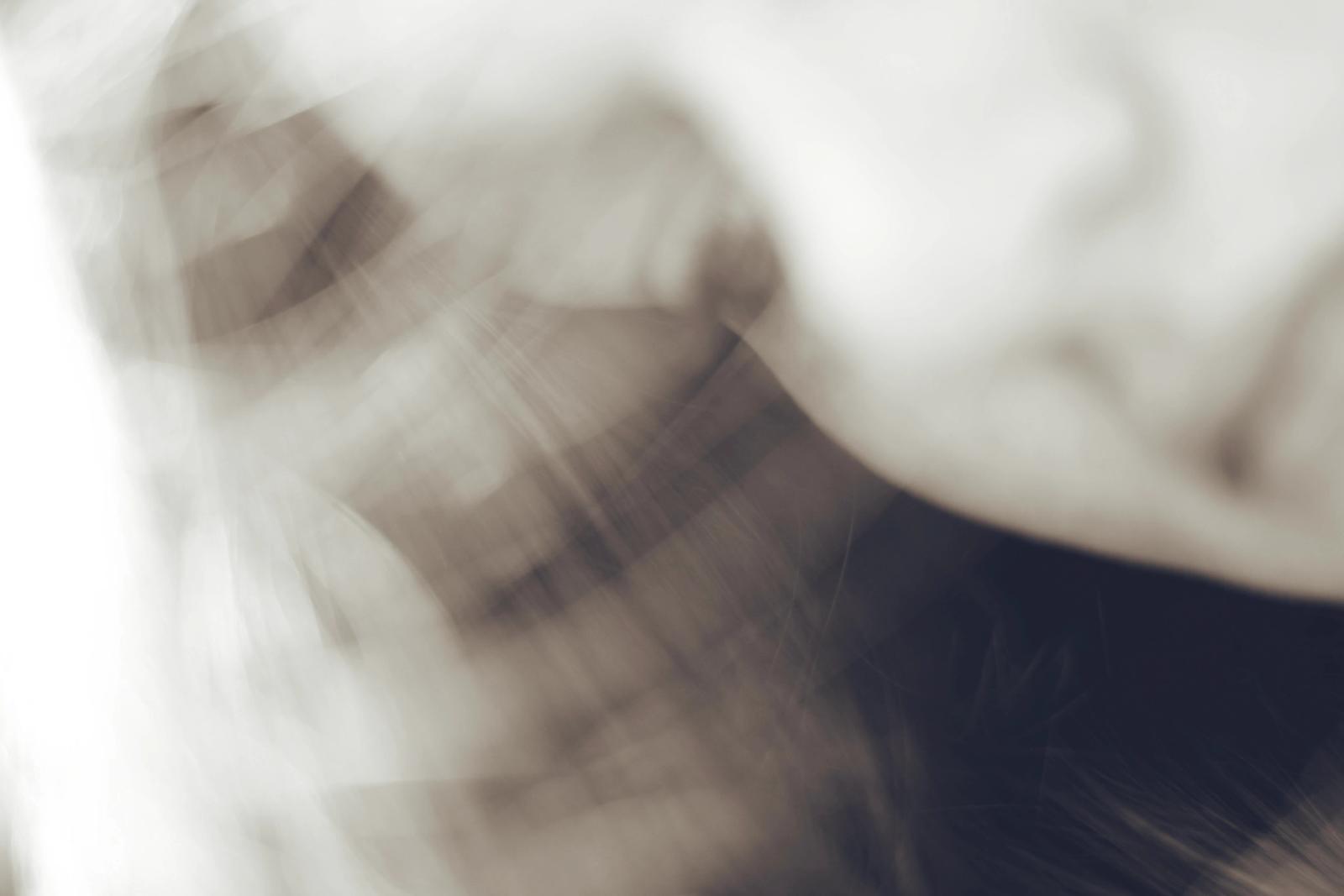 Abstract sepia-toned motion blur of plaid fabric and skin, streaked with light trails.
