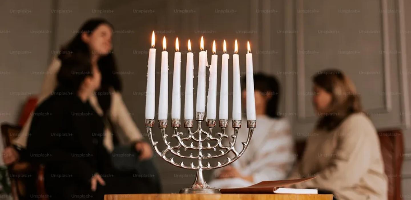 A set Shabbat table with candles and challah
