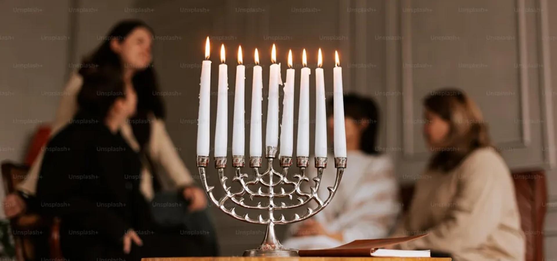 A set Shabbat table with candles and challah