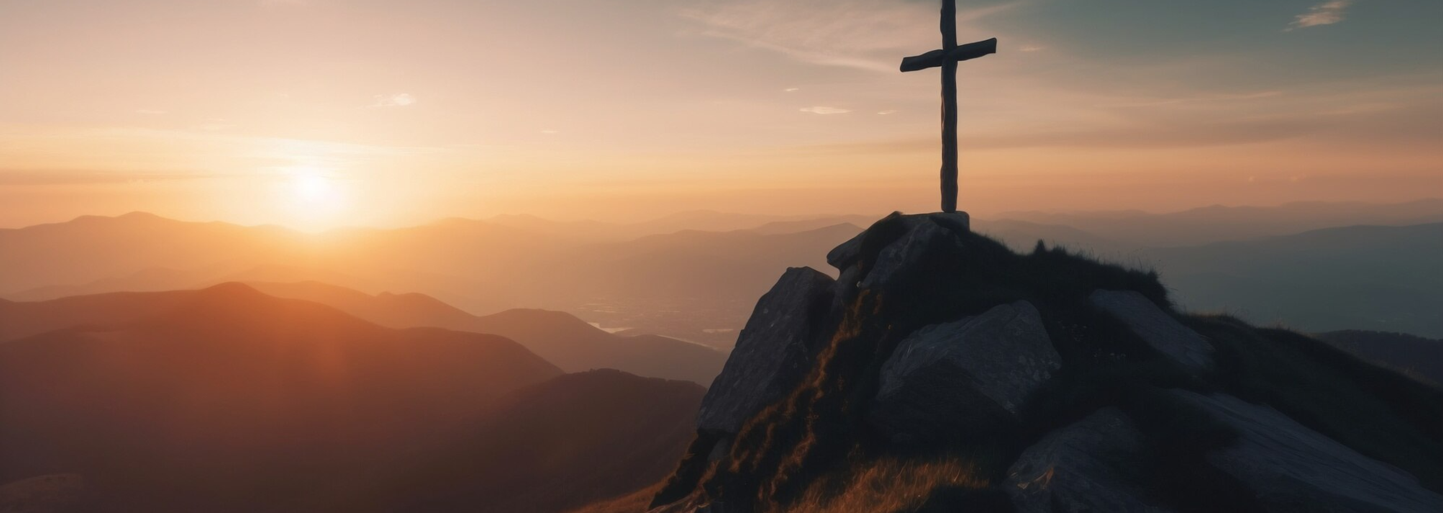 Silhouette of a cross on a mountain ridge at sunset