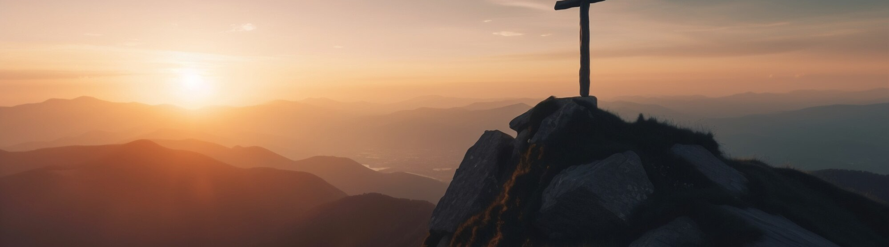 A mountain summit cross at sunrise