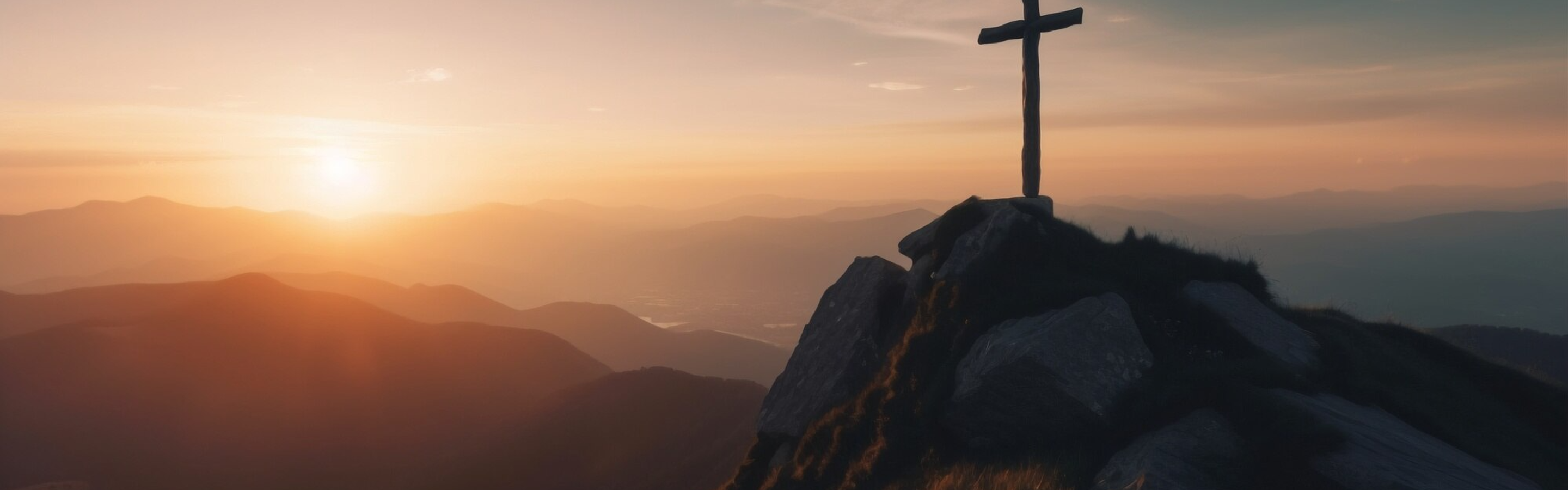 Silhouette of a cross on a mountain ridge at sunset