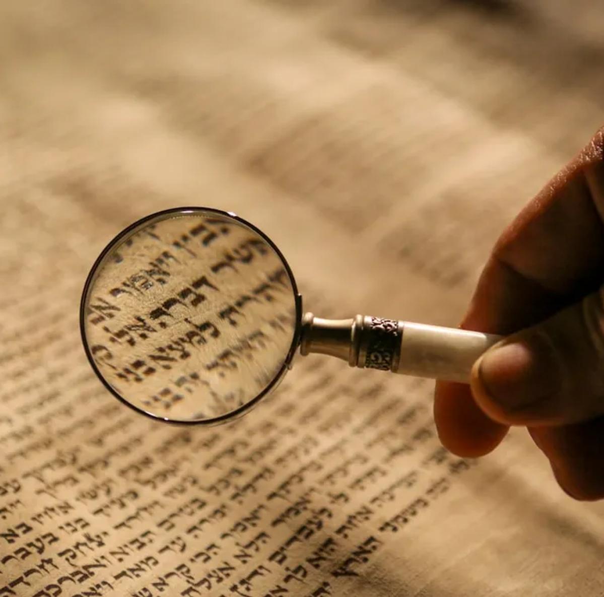 A magnifying glass over Hebrew text