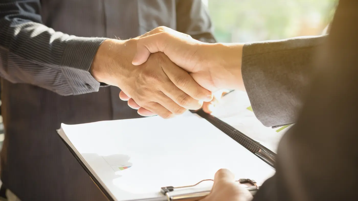 Handshake between two people finalising a moving company agreement.