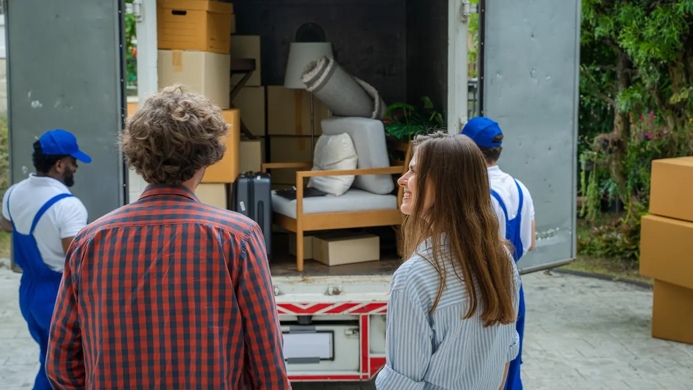 Professional movers loading furniture and boxes into a moving truck.