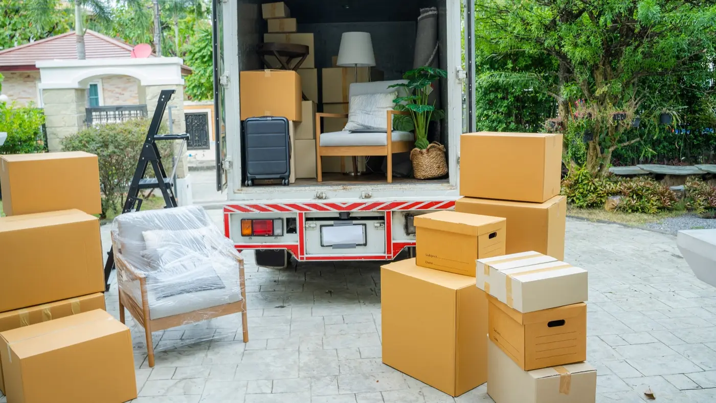 Moving truck loaded with packed furniture, household items, and cardboard boxes for relocation.