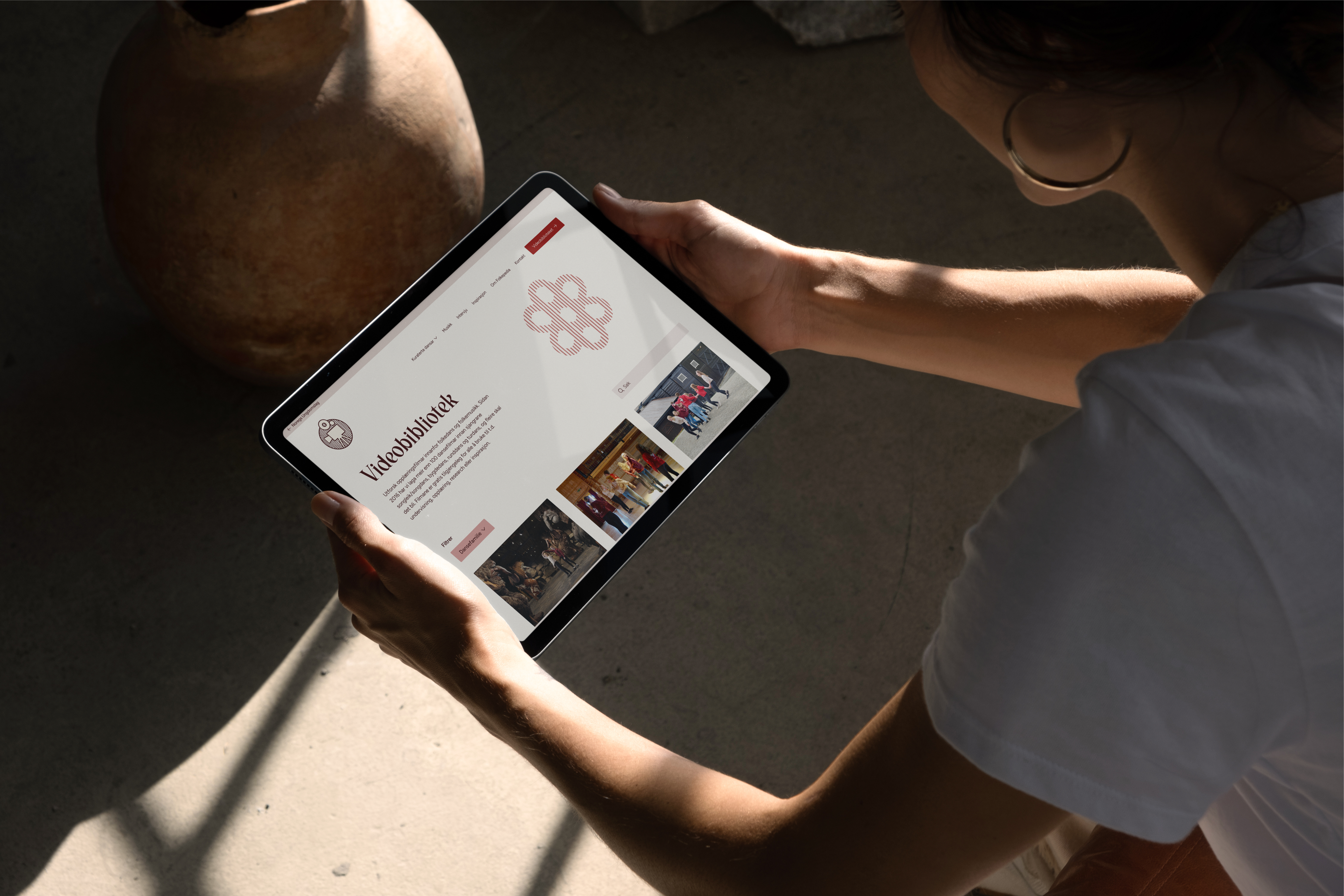 a woman is holding a tablet with a website on it