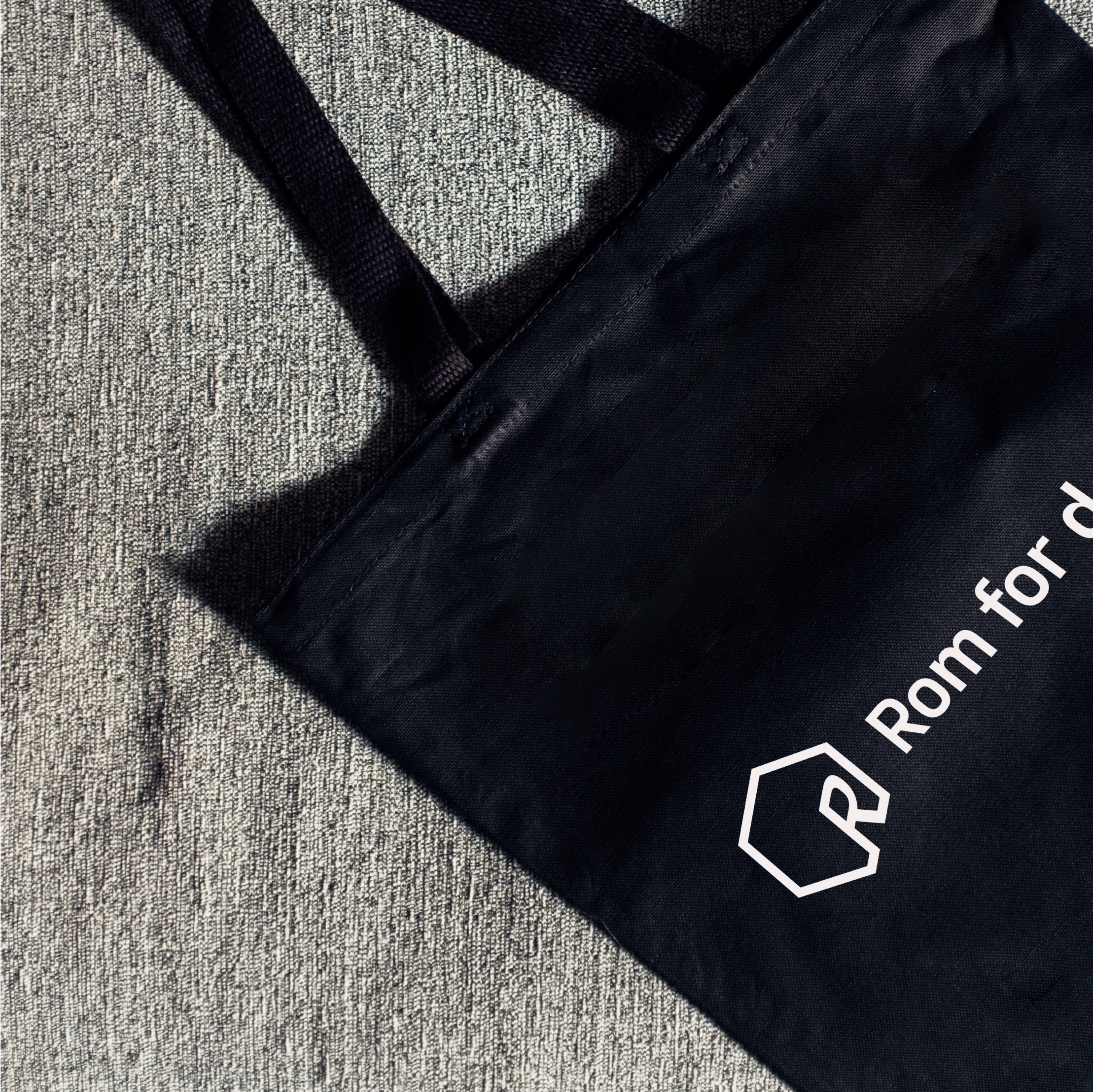 en svart tote-veske med rom for dans logoen