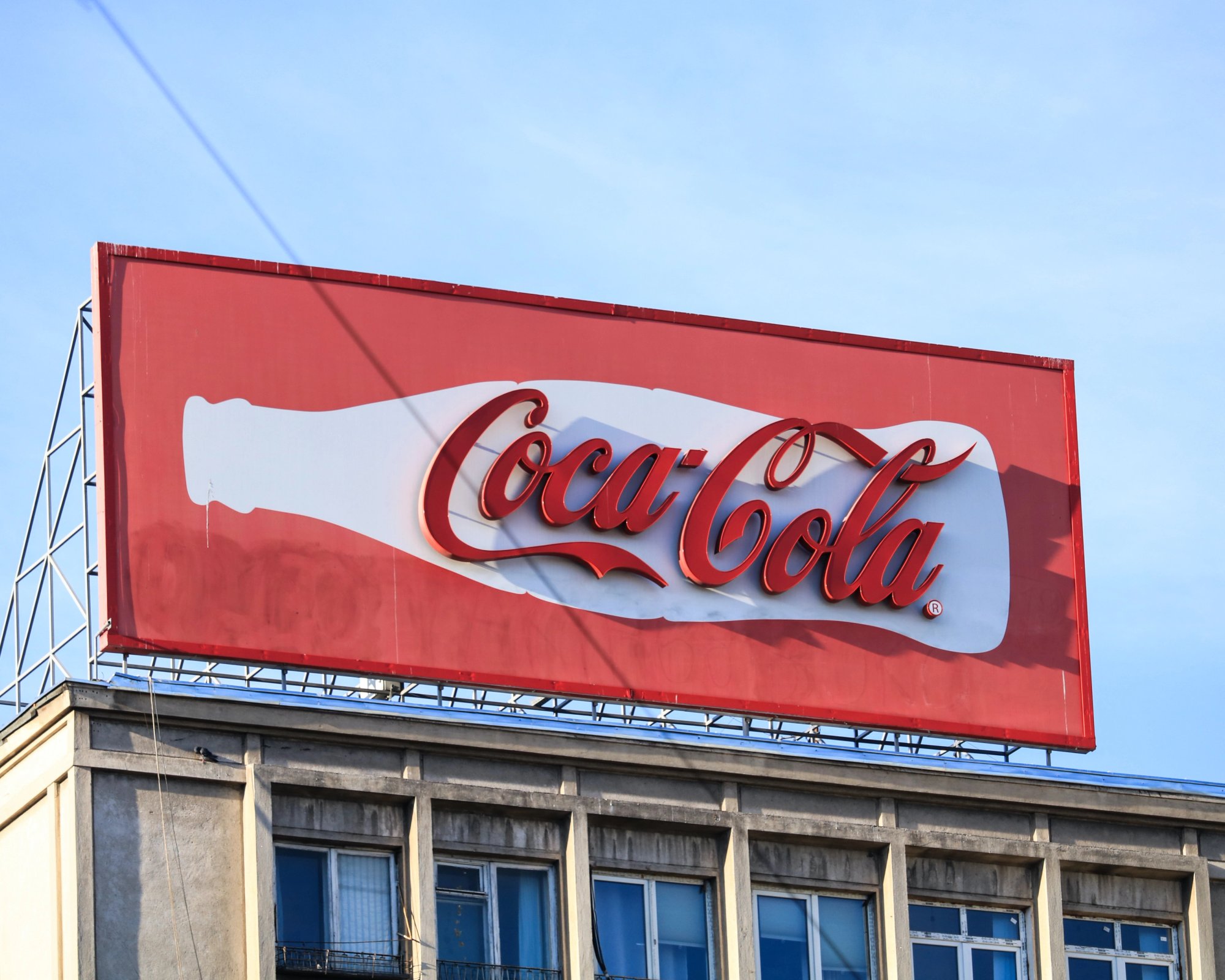 Coca Cola logoen på et billboard i sola