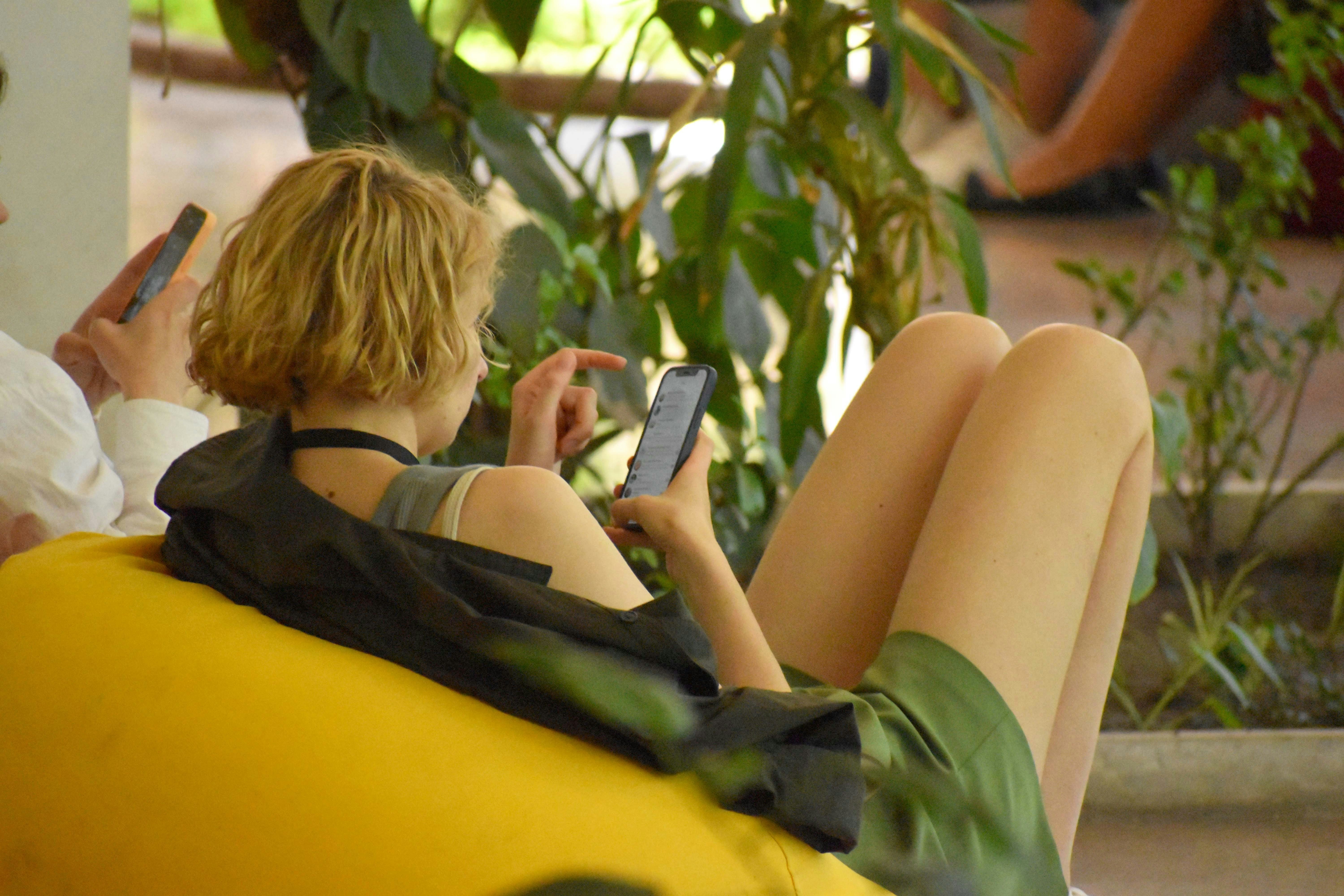 Two people scrolling on their phones.