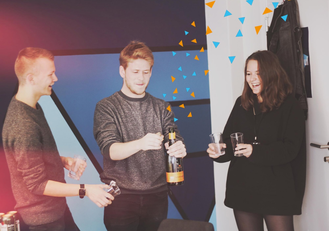 Kult-gjengen som spretter en champagne for å feire. Det er lagt til konfetti på bildet. 