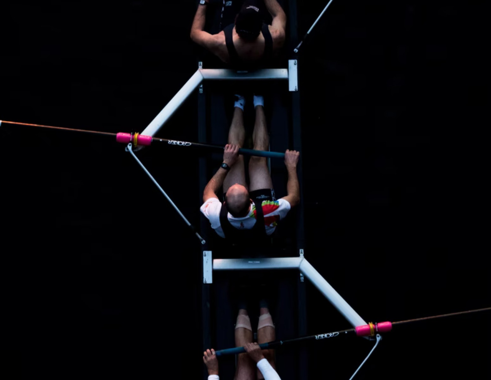 En gruppe menn ror en båt i et mørkt rom.