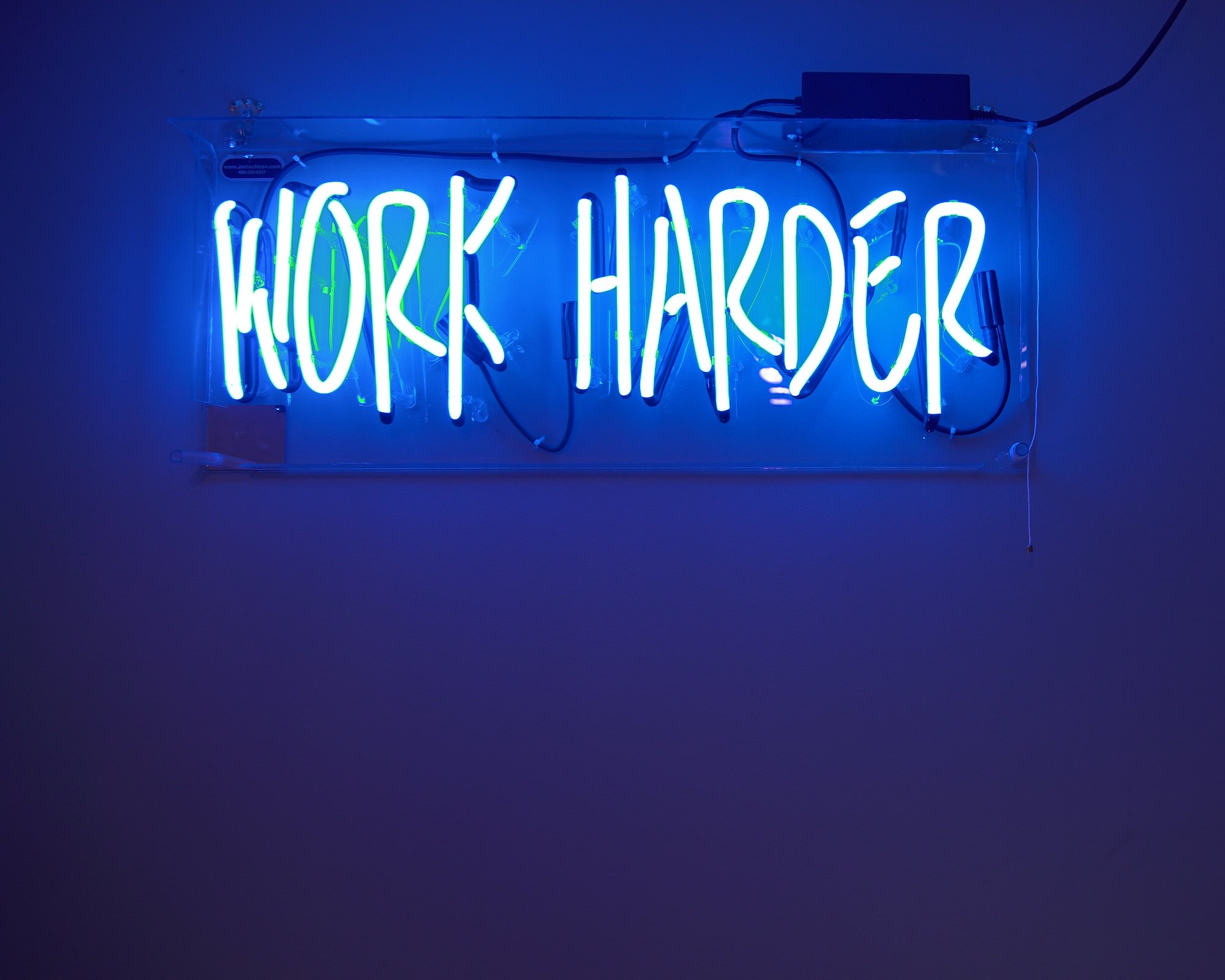 Work harder i neon lys. Foto.