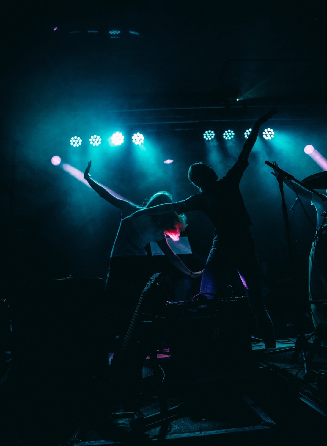 Band som opptrer på en scene med lyskastere. Foto