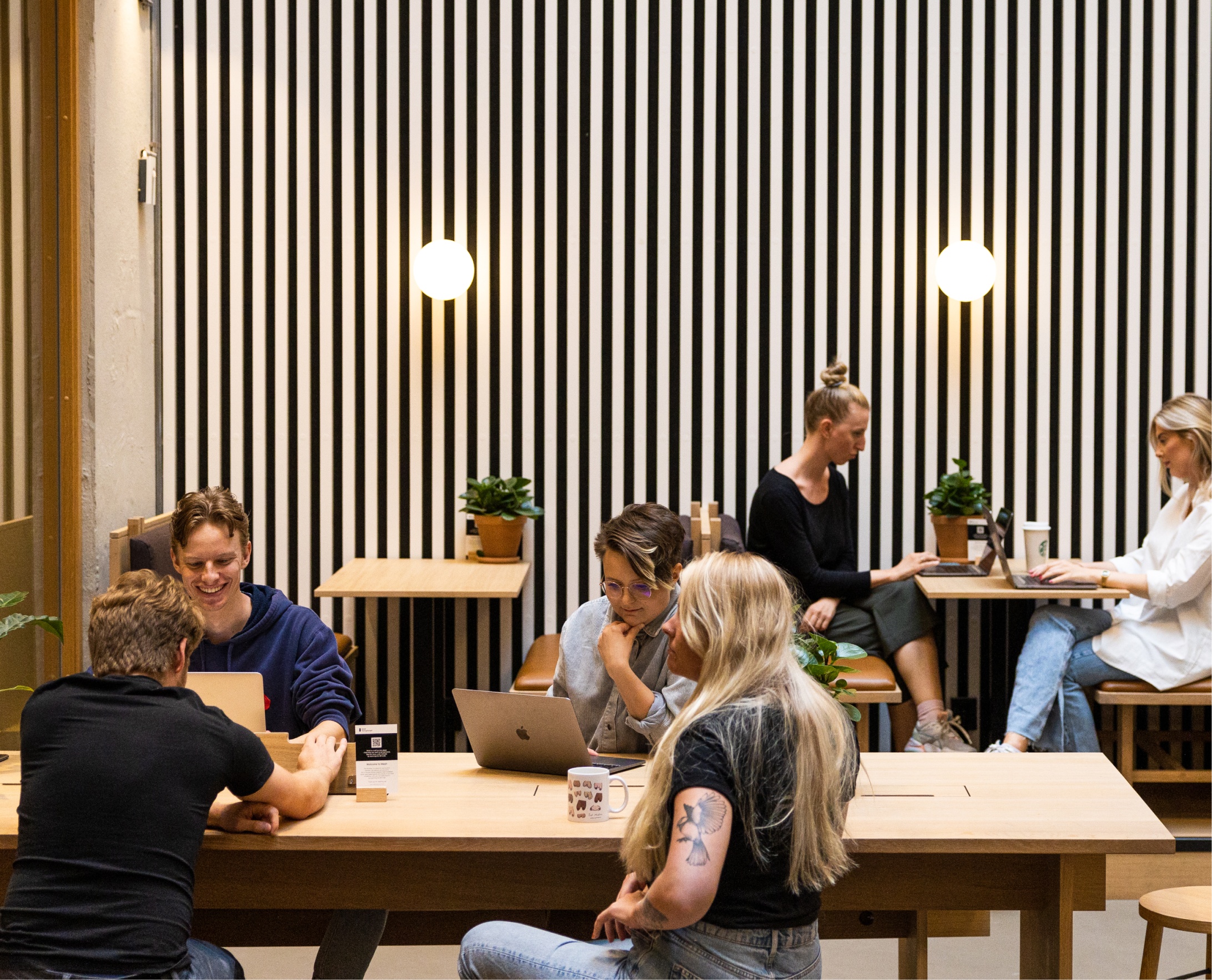 Kult gjengen sitter ved to bord og jobber. Foto.