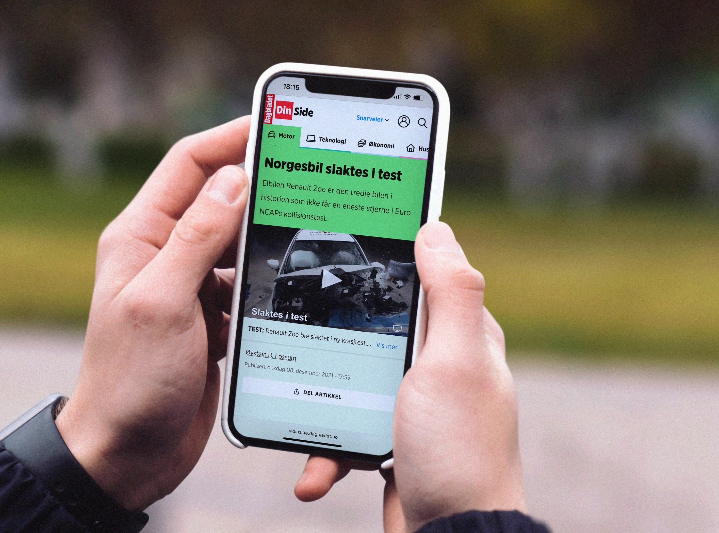 Artikkel om bil fra DinSide på mobil. Foto.