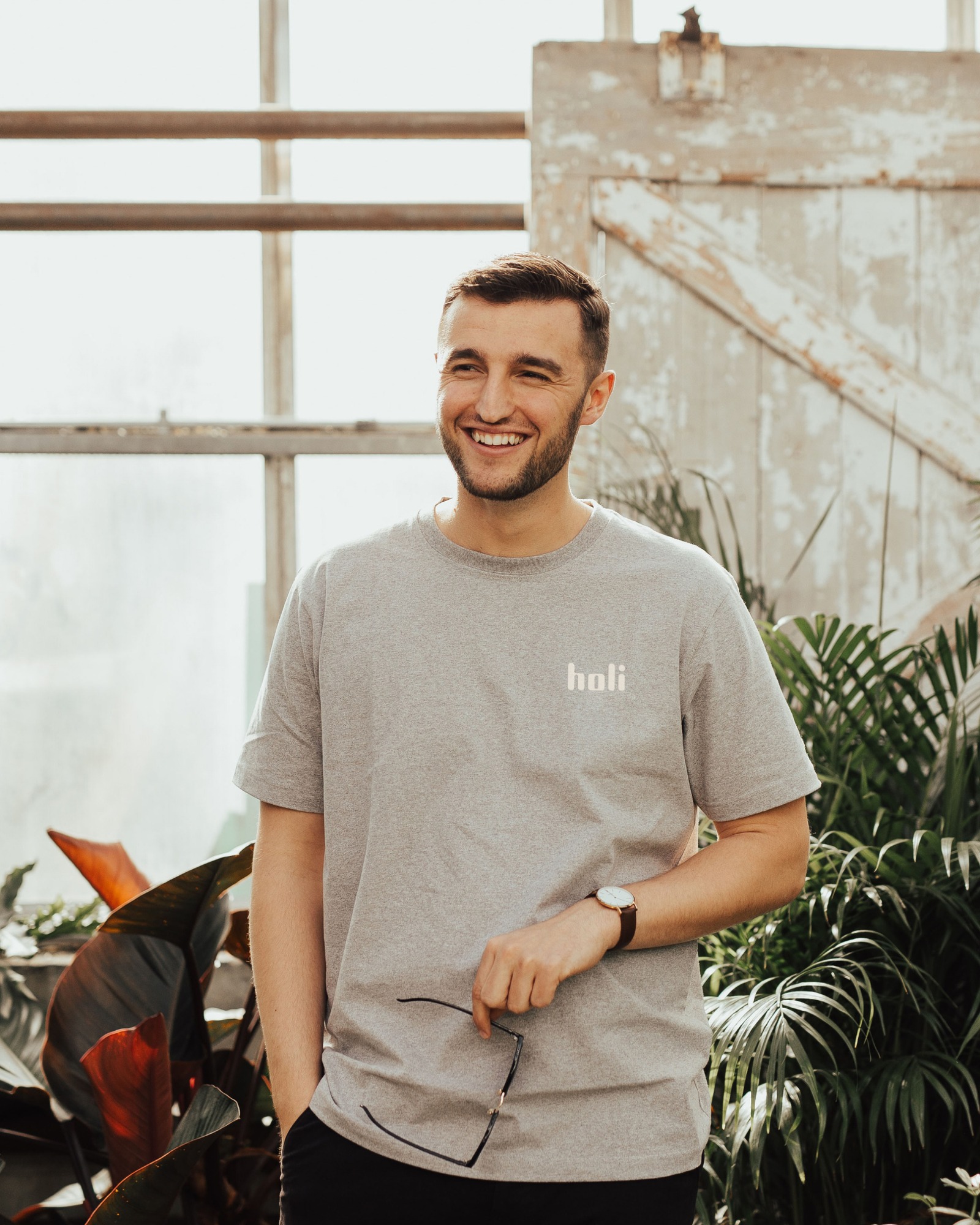 Person med t-skjorte med Holi logo smiler. Foto.