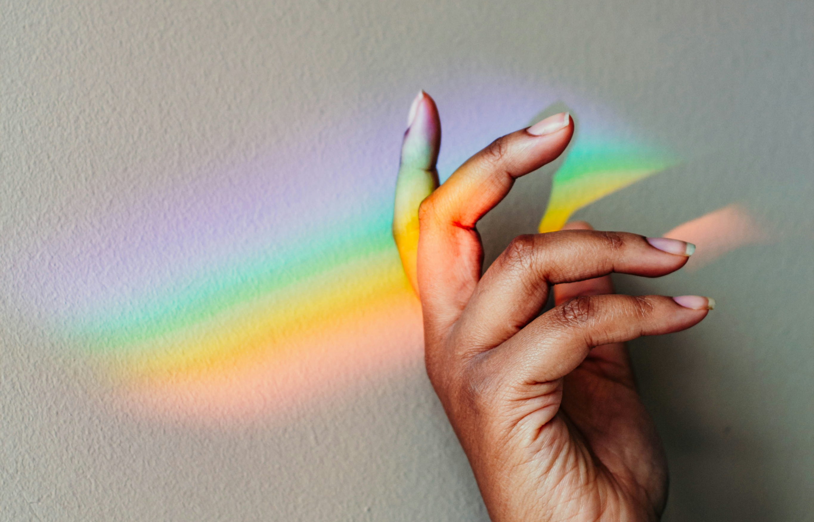 a rainbow is reflected on a tile floor next to a door mat .