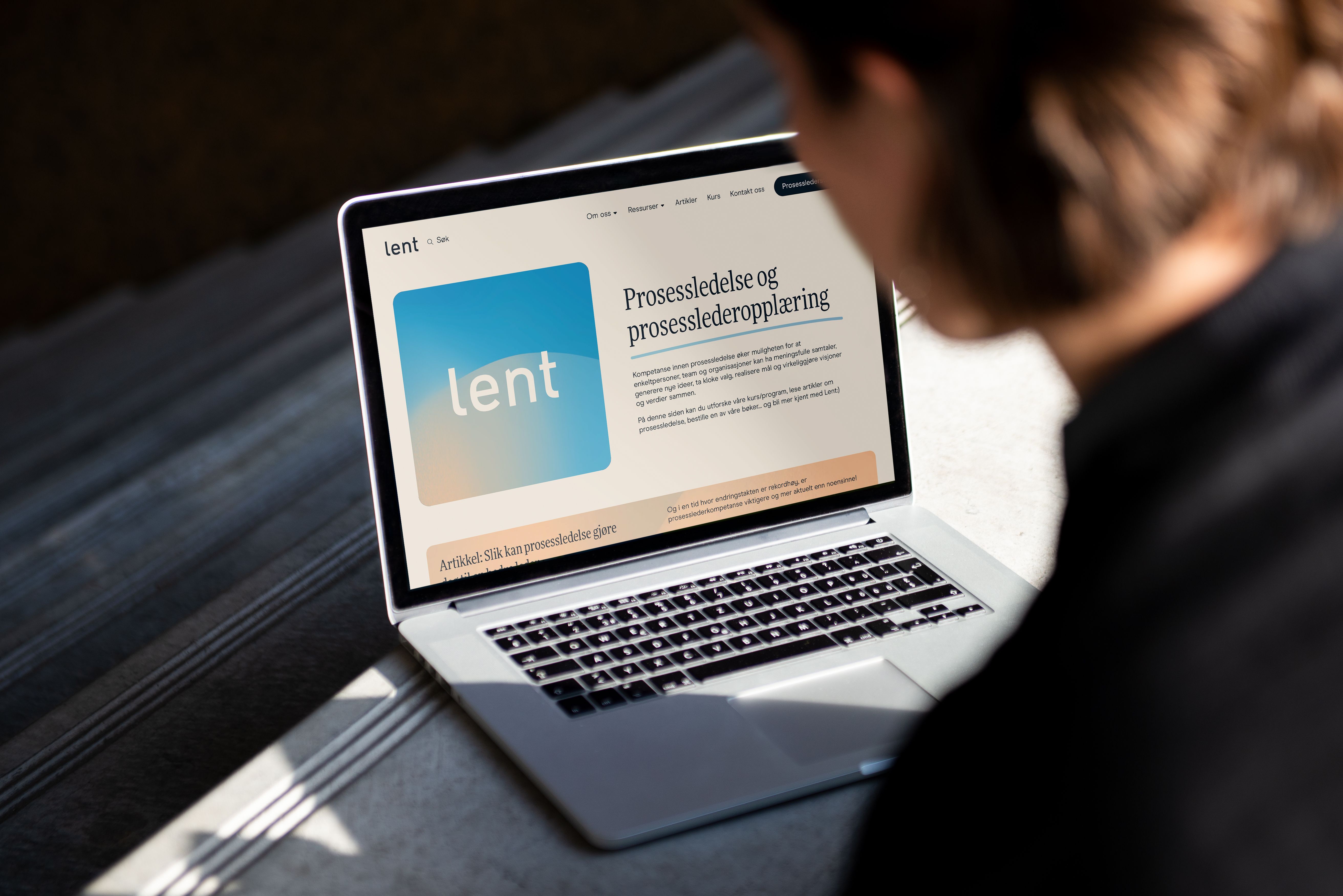 A person looks at a laptop displaying a website about process leadership training.