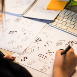 Caroline lager grove skisser ulike versjoner av logoer for Sakte film pÄ papir.