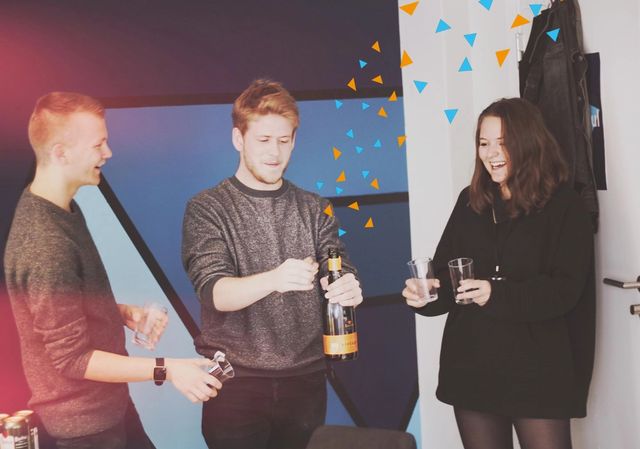 Kult gjengen som spretter en champagne for Ä feire. Det er lagt til konfetti pÄ bildet.