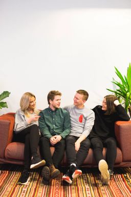 Kult gjengen sitter i en sofa og ler