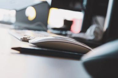 Tastatur og datamus på et skrivebord. Foto