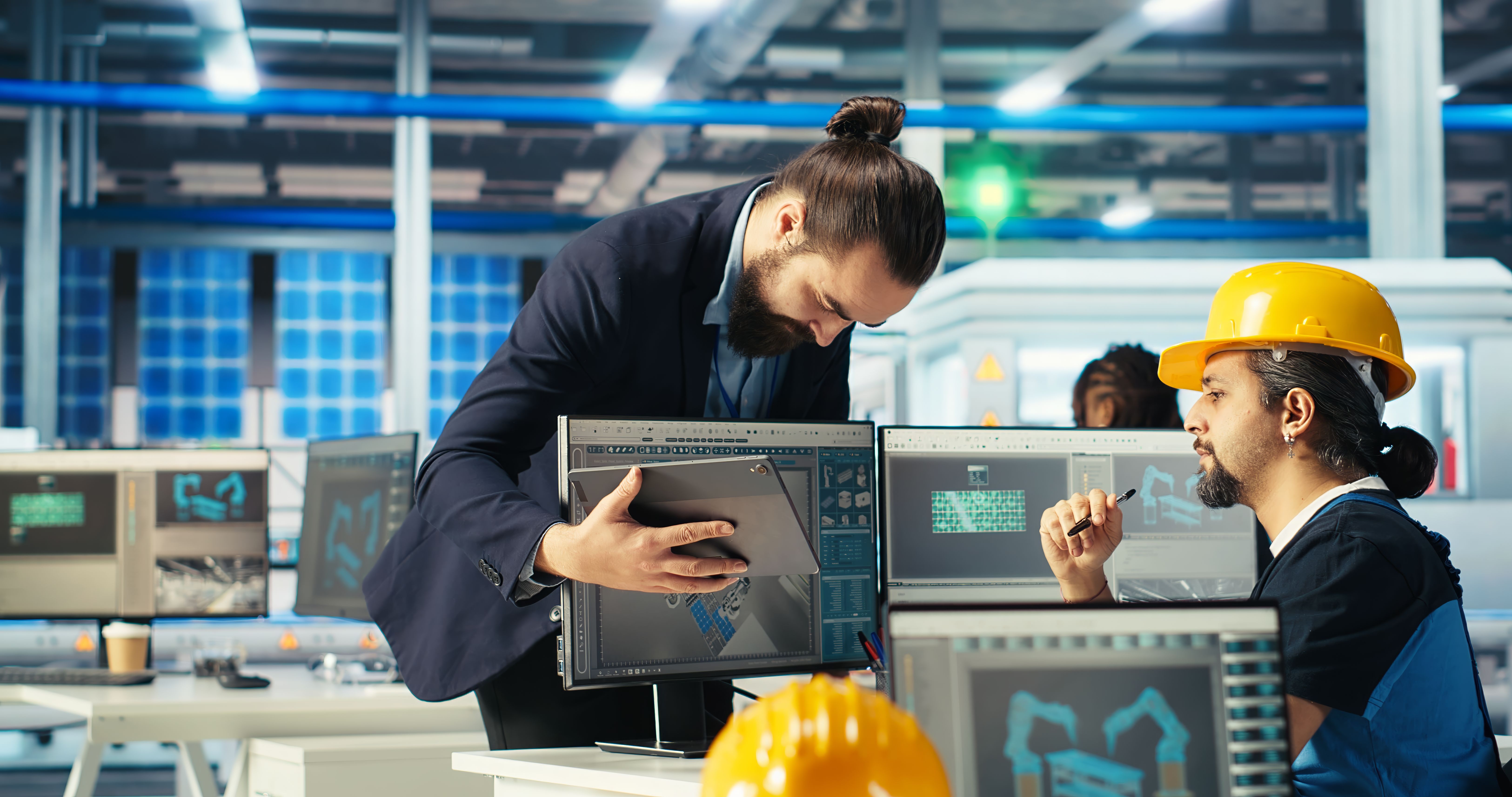 a man in a hard hat looking at a computer screen