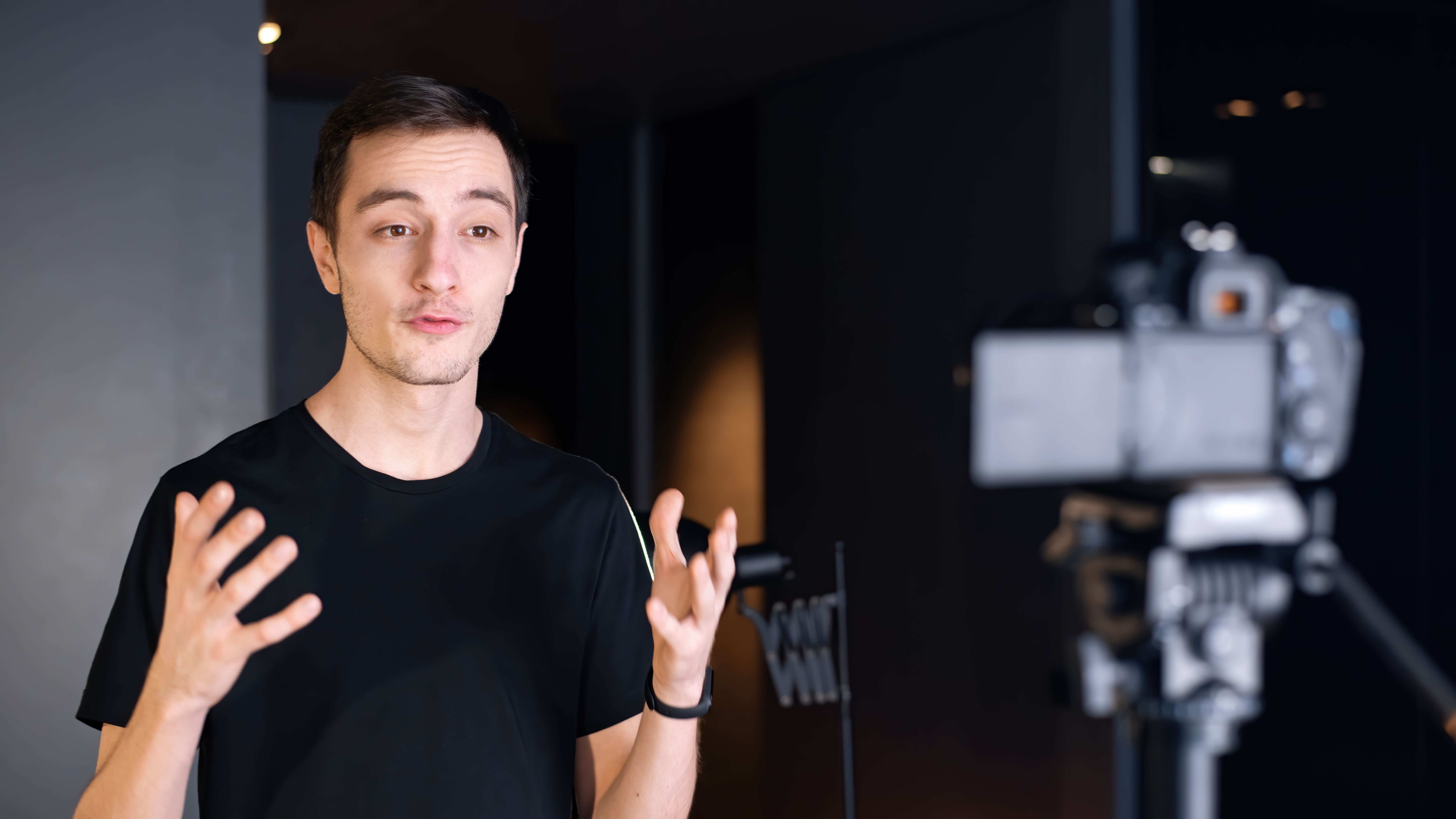 a man standing in front of a camera holding his hands out