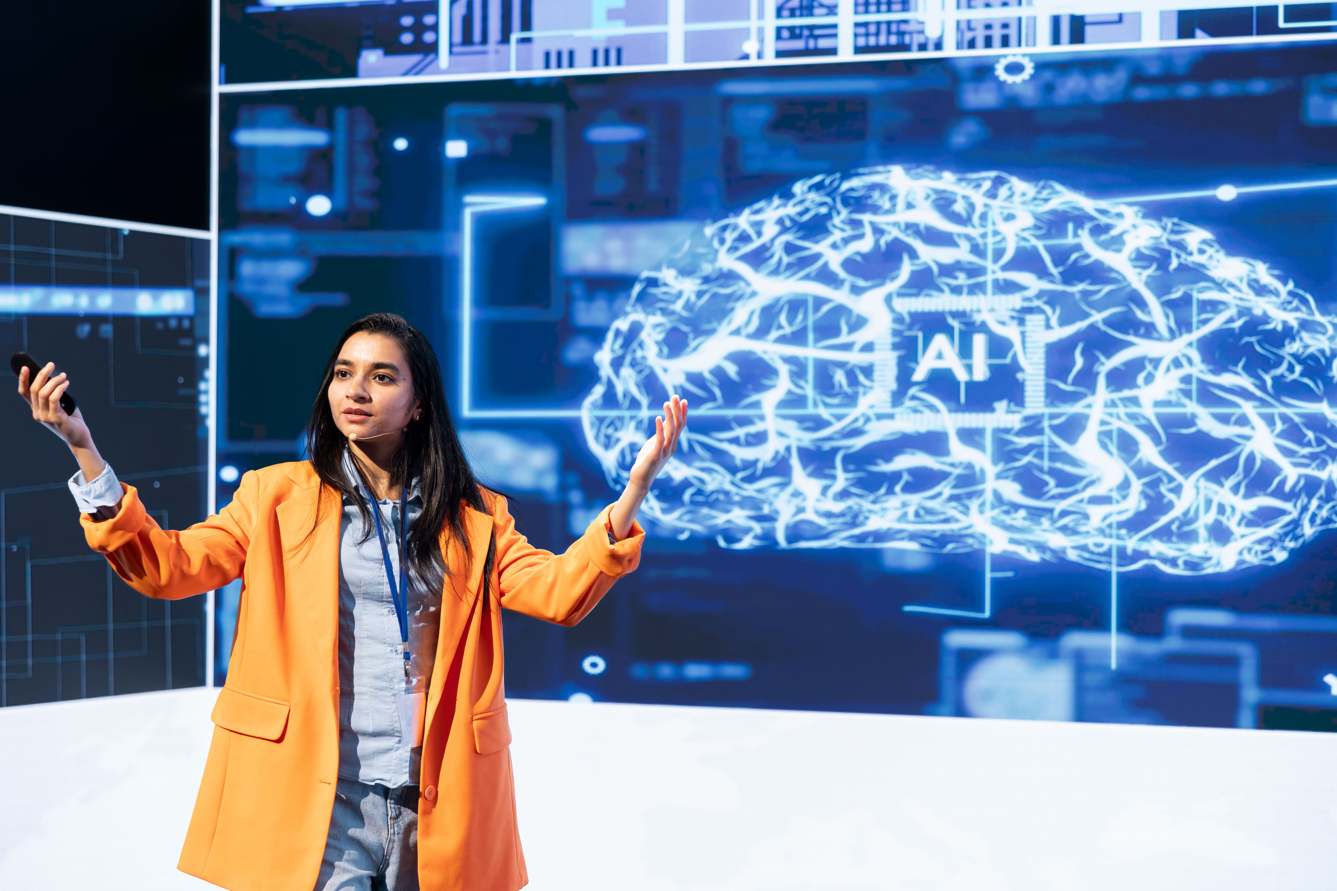 a woman standing in front of a projection of a brain