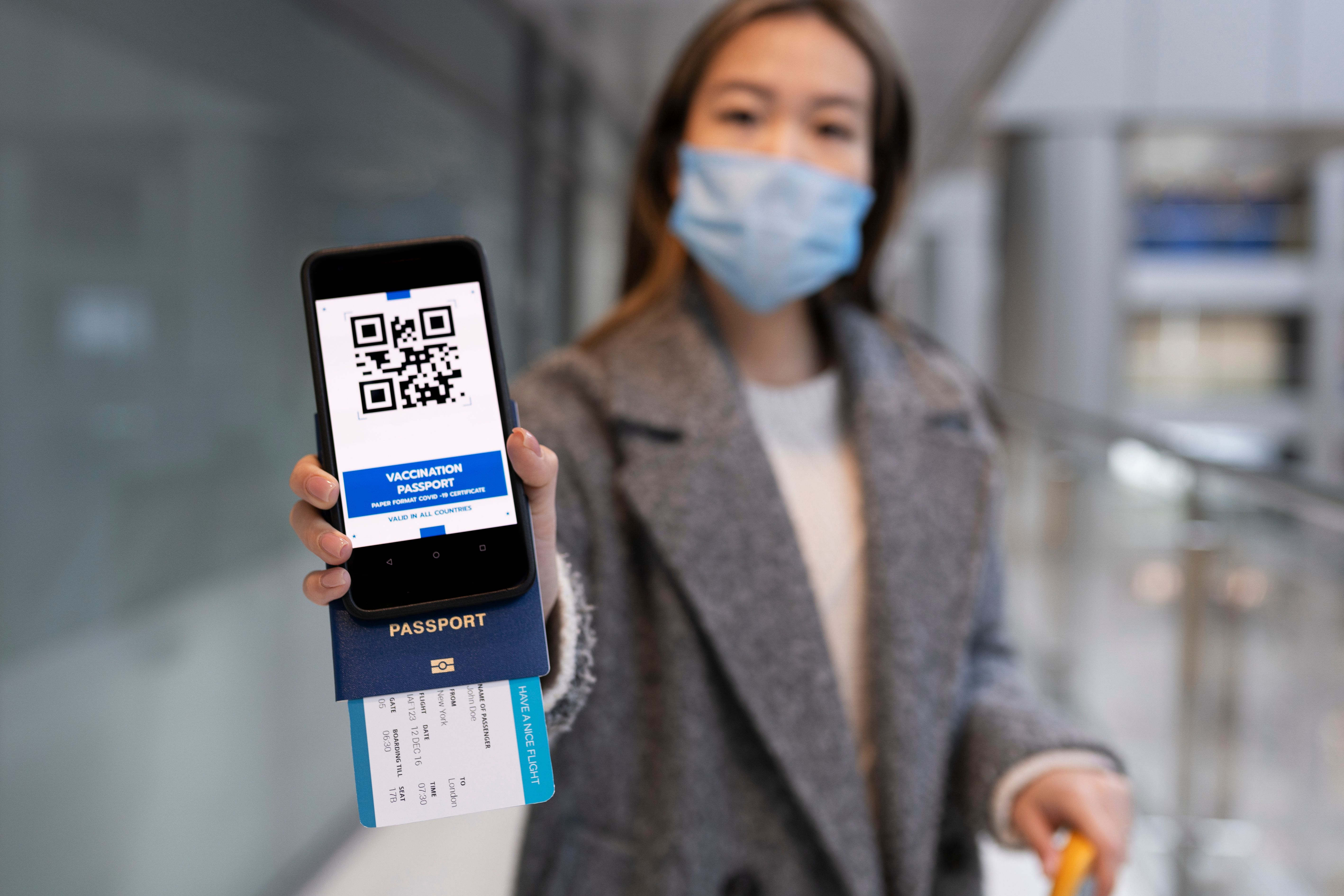 a woman wearing a face mask while holding a smart phone