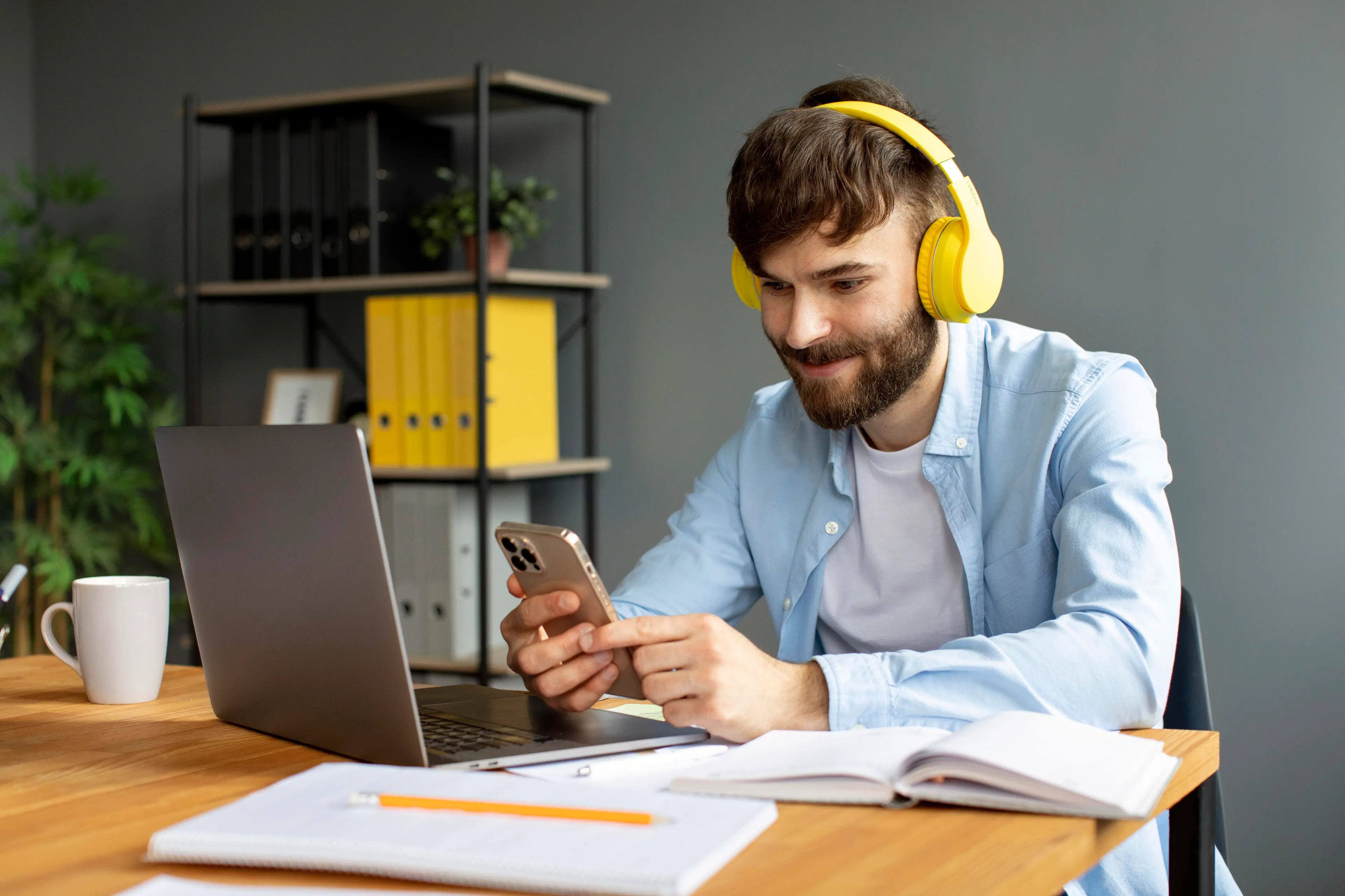 a man sitting at a table with a laptop and headphones on