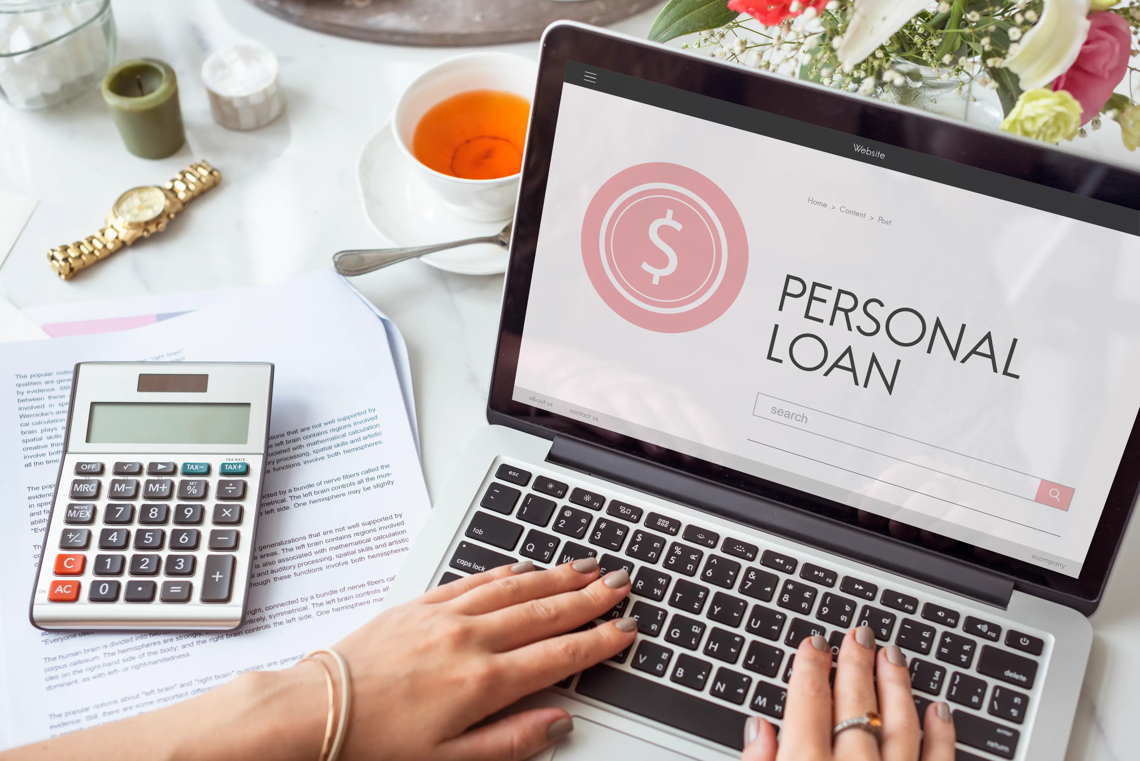 a woman is typing on a personal loan on a laptop