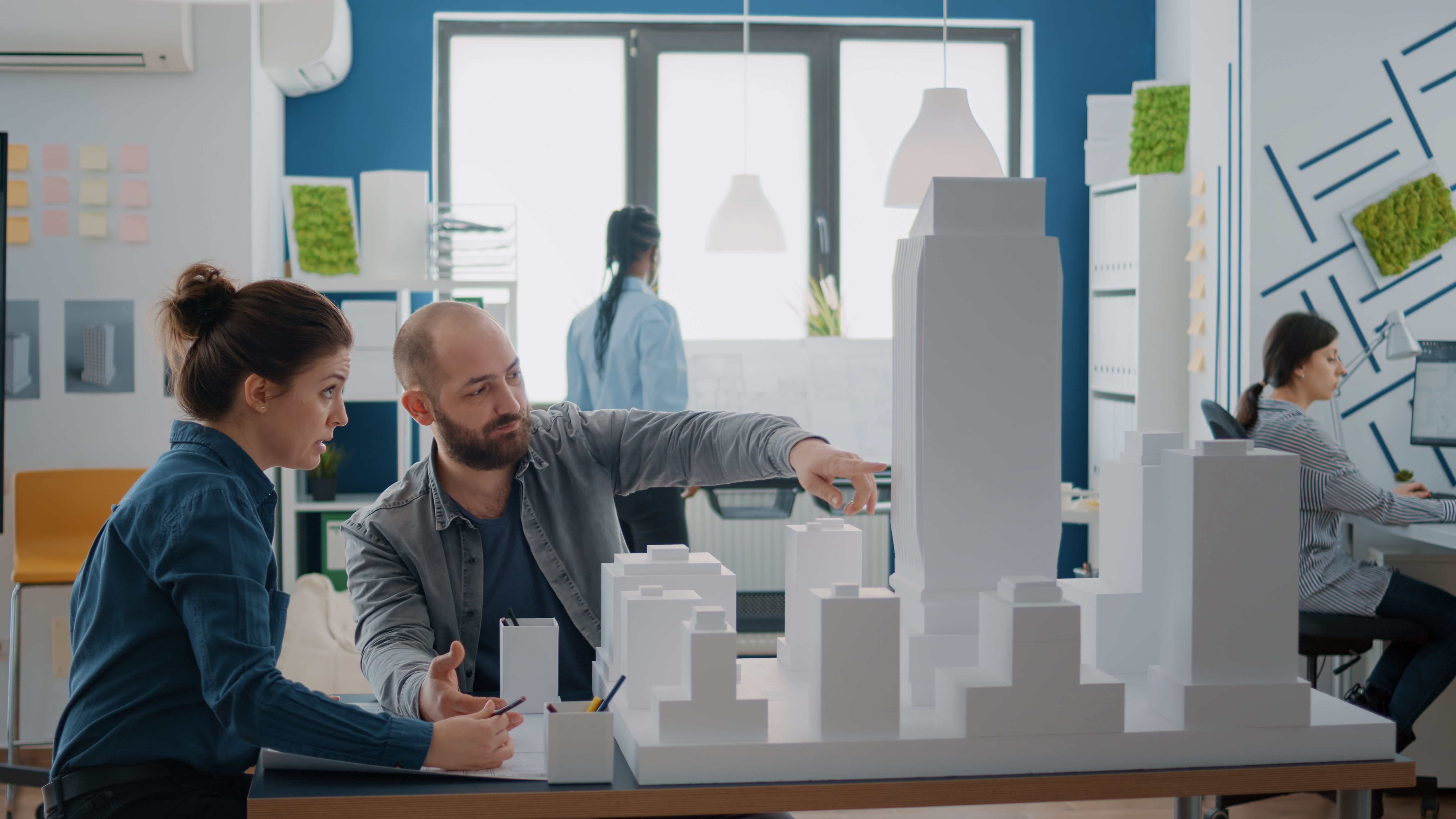a man and woman looking at a model of a city