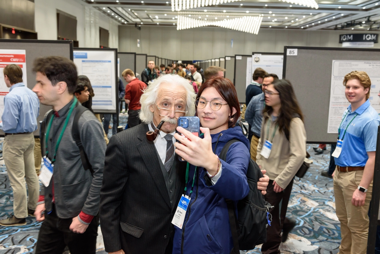 An attendee at APS March Meeting 2023 takes a selfie with Albert Einstein.
