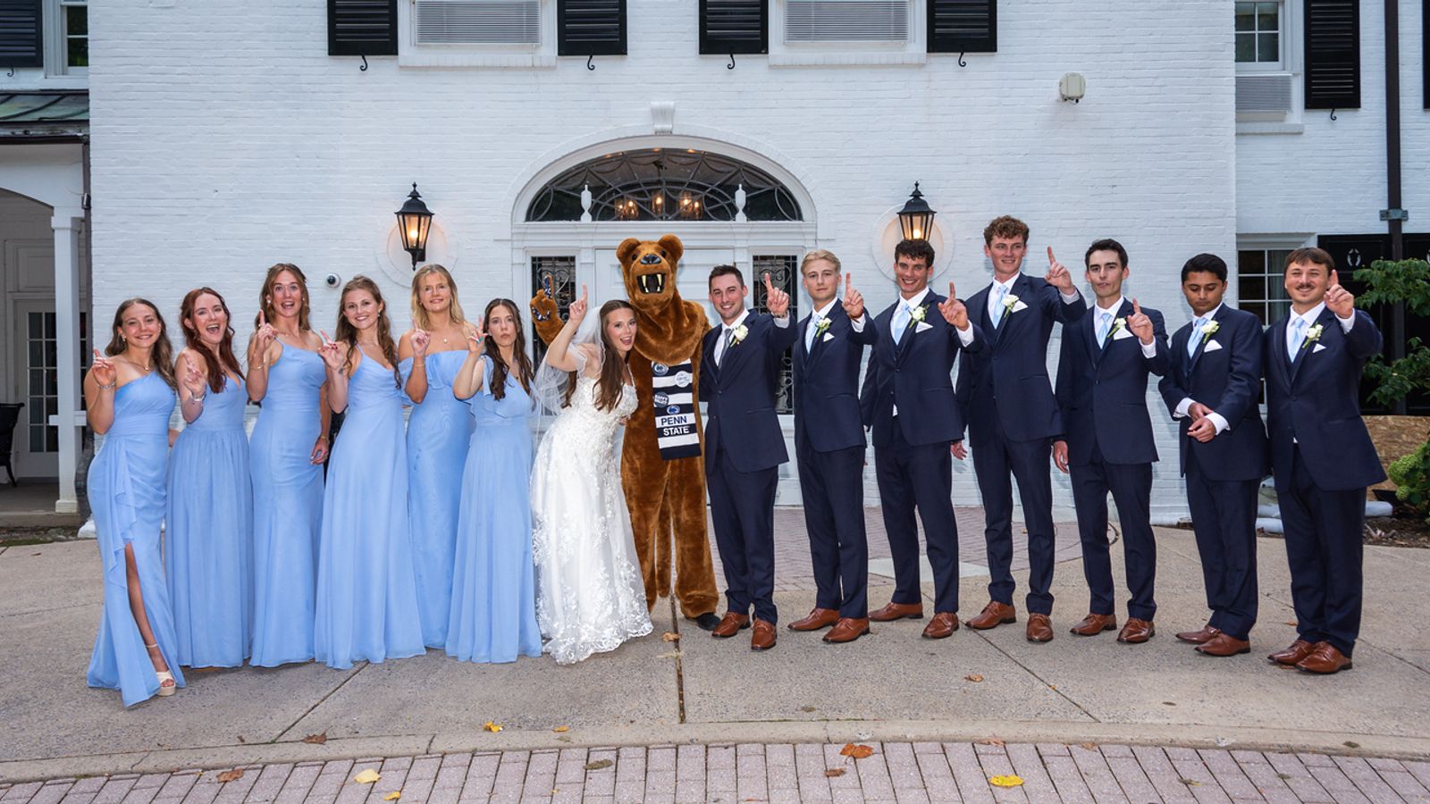 Meg and Billy with their wedding party and the Nittany Lion outside The Nittany Lion Inn in State College, PA