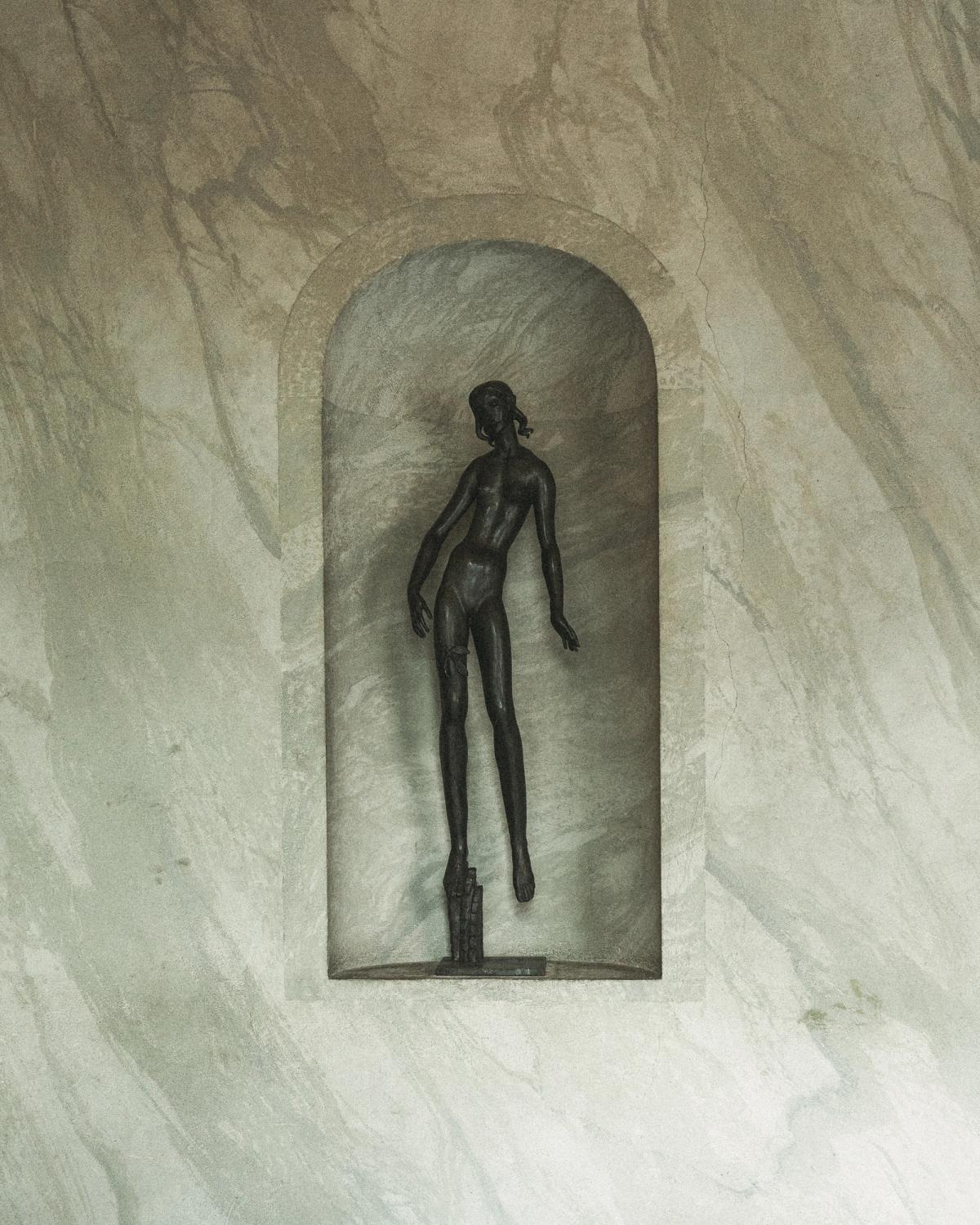 Une fine sculpture en bronze exposée dans une niche murale en marbre à la Salle de concert de Stockholm.