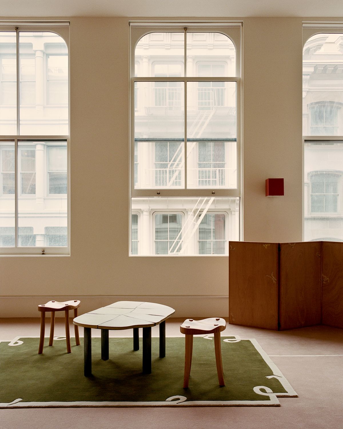 Der Teppich Loops Green wird im Studio von Giancarlo Valle zusammen mit einem Hocker und einem Tisch gezeigt, die ebenfalls von ihm entworfen wurden.