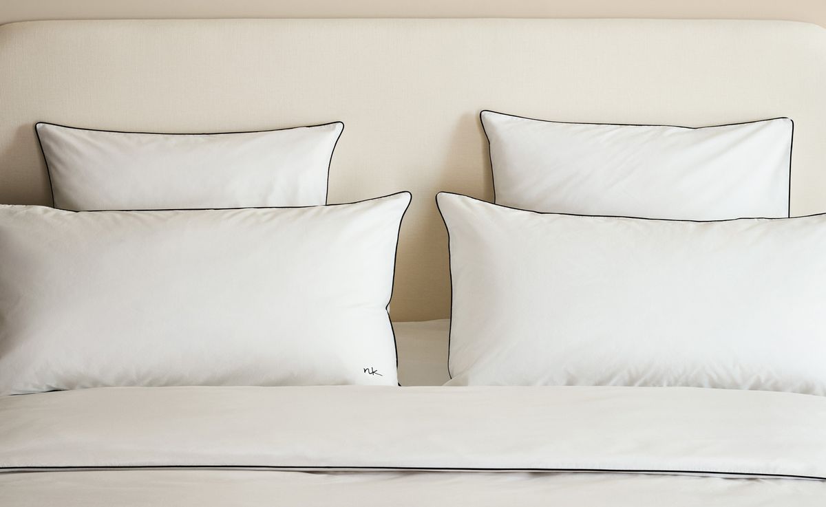 Percale Bettbezug-Set in Crisp White/Black, auf einem Bett arrangiert, aus weißer Baumwollperkal mit feiner schwarzer Paspelierung für einen klaren, grafischen Look.