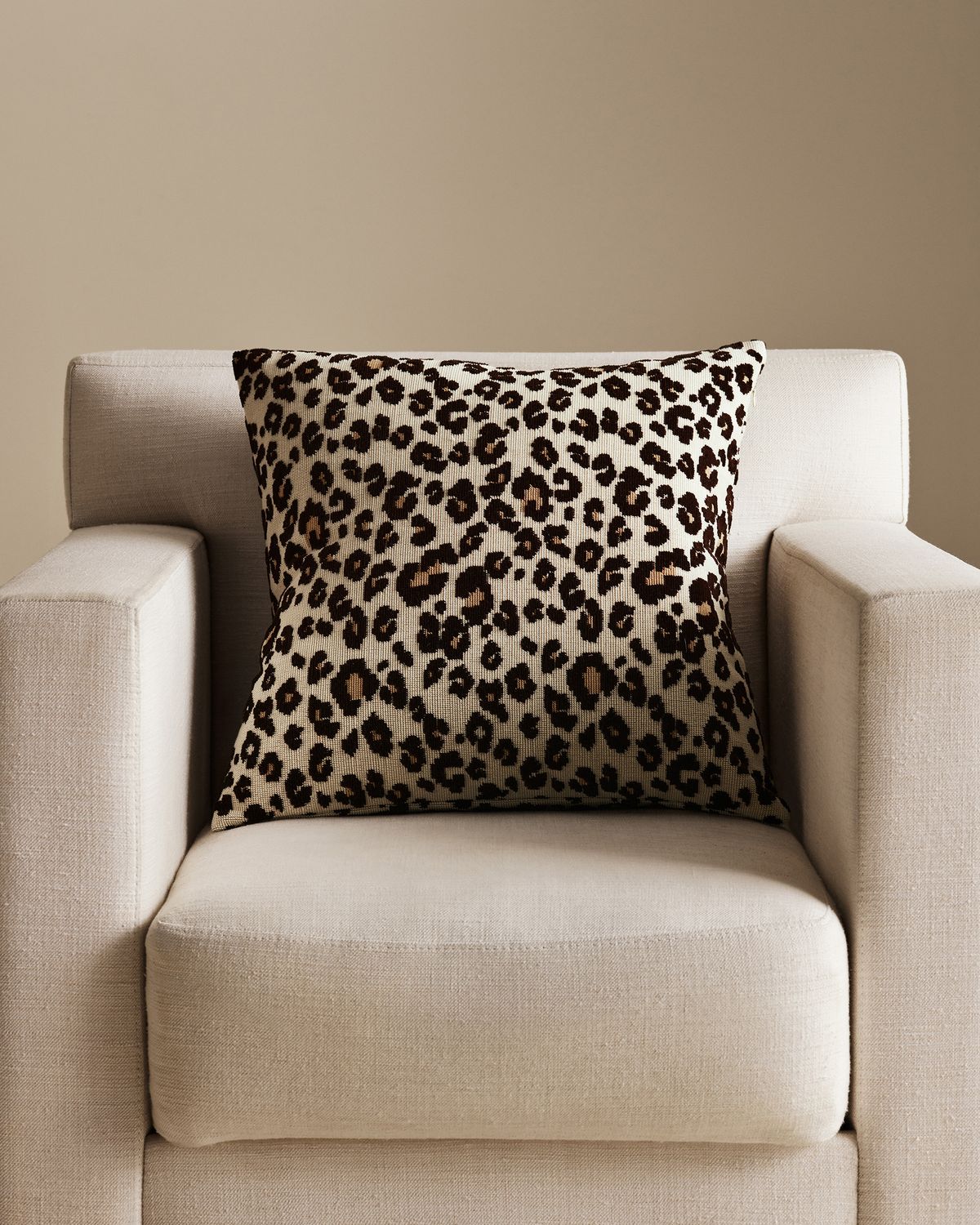 Leopard Pillow Cover in Beige, styled on a neutral armchair.