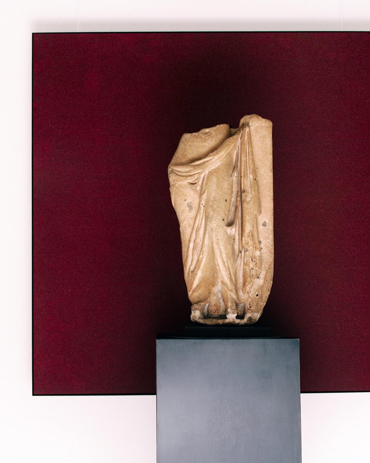 A painting of the Grand rug in Deep Wine hanging on the wall behind a statue at Galerie Chenel in Paris.