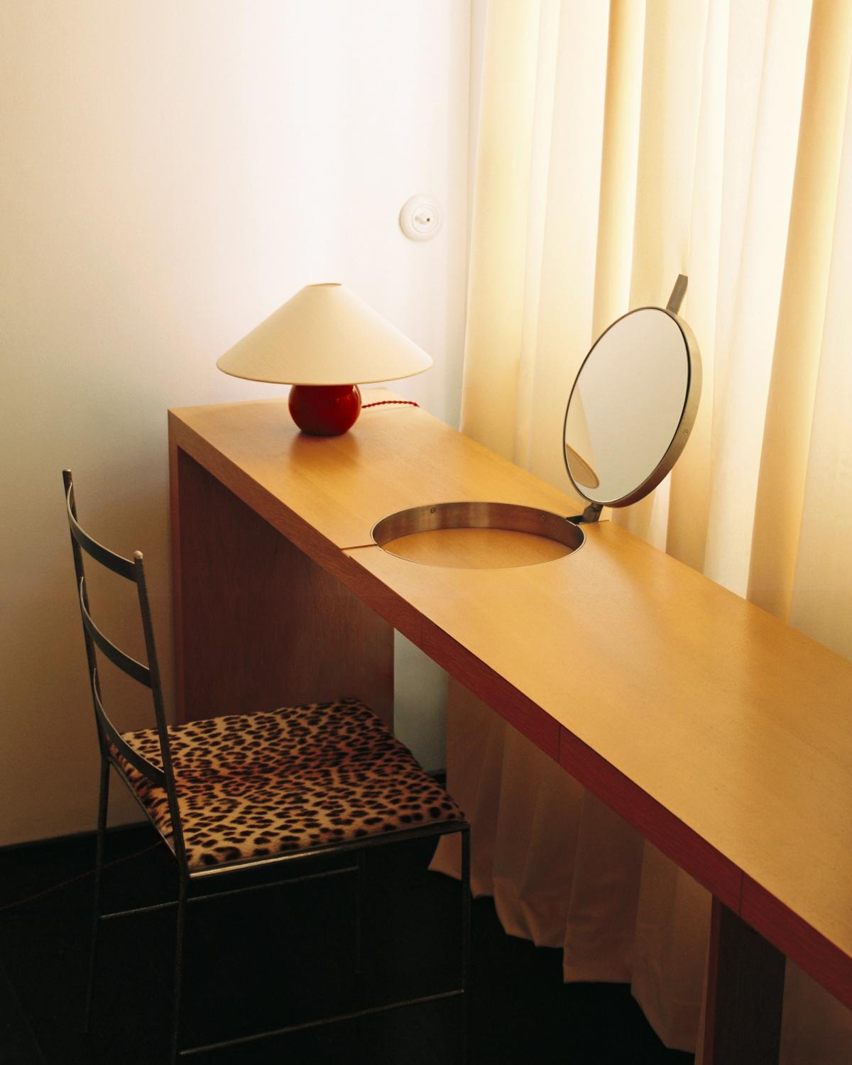 The Sheer in Sunrise, photographed in soft morning light beside a wooden vanity, where the sheer warm-white curtains create an airy, sunlit feel.