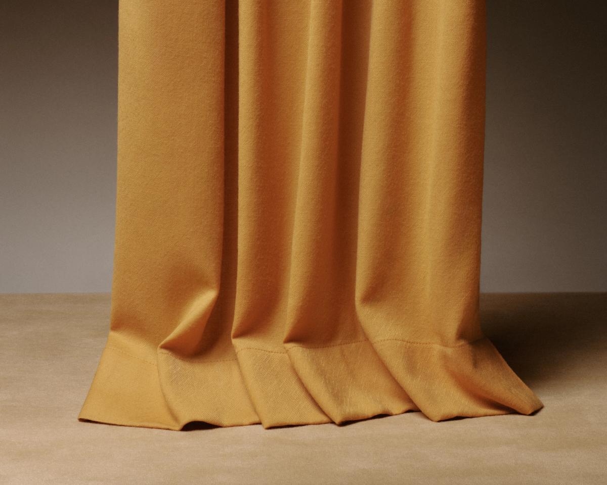 An image of a panel of curtains touching the ground, creating a beautiful slouching effect.