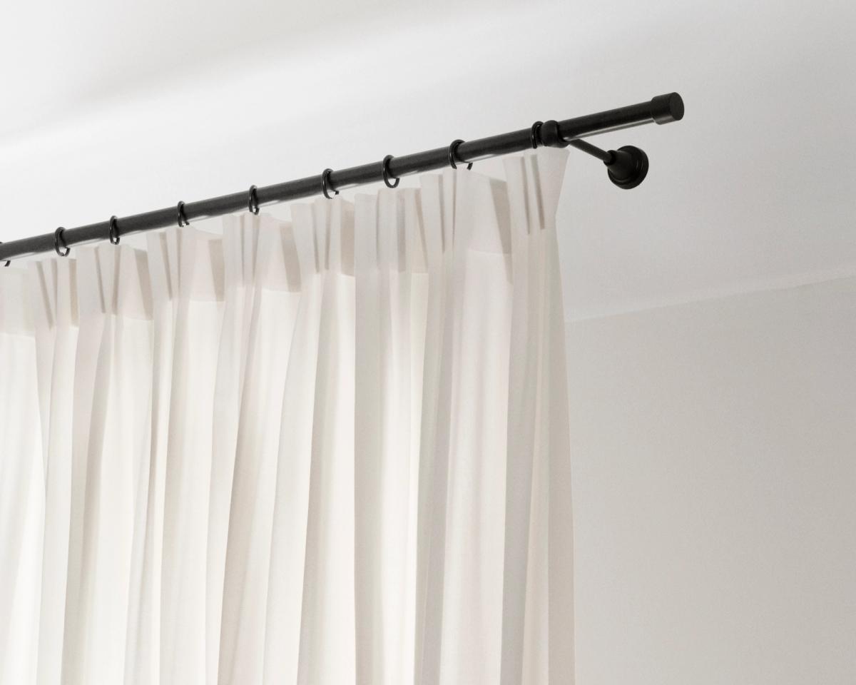 Ein Bild, das die installierten Wollvorhänge The Grand mit 4-Finger-Haken an einer Stange zeigt.