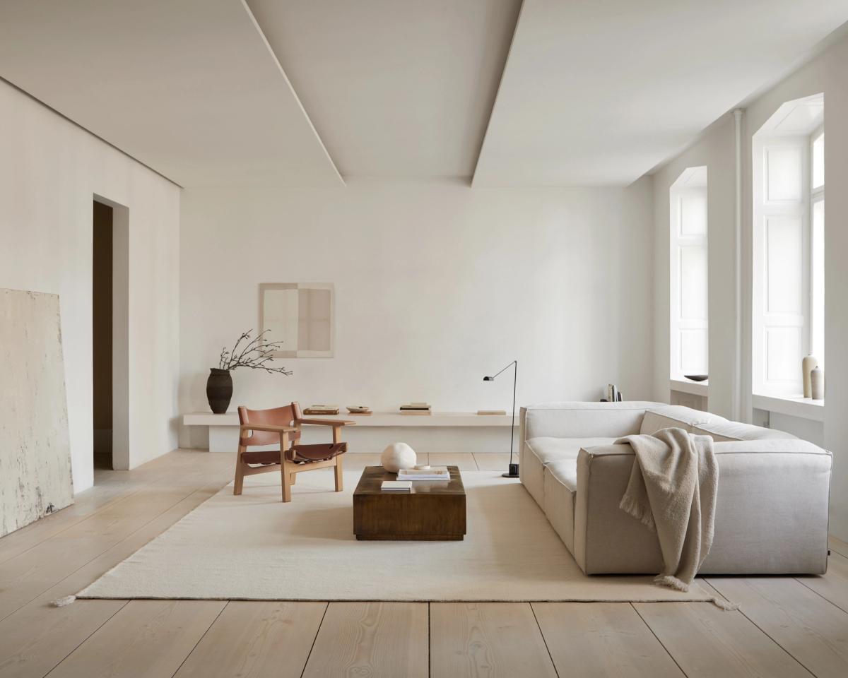 Tapis Merino Natural White photographié dans un salon moderne blanc.