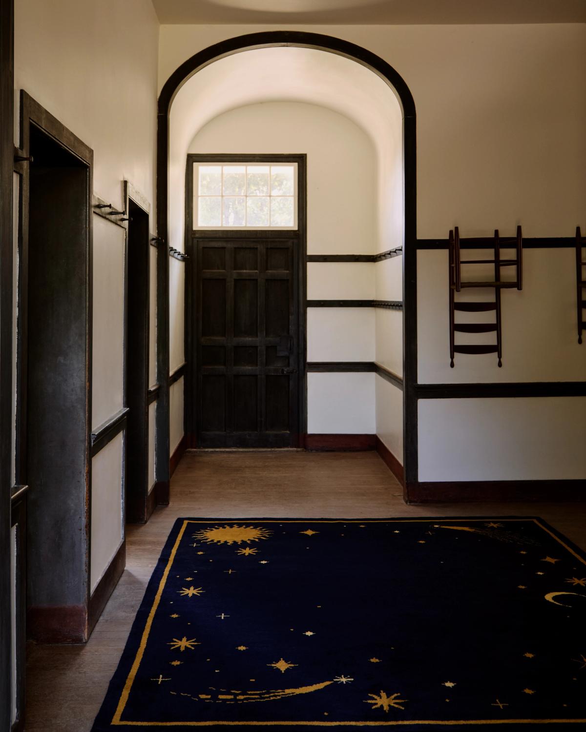 Tapis en laine moelleux Celestial, en collaboration avec ASH, photographié dans un vaste hall d’entrée avec des poutres en bois apparentes.