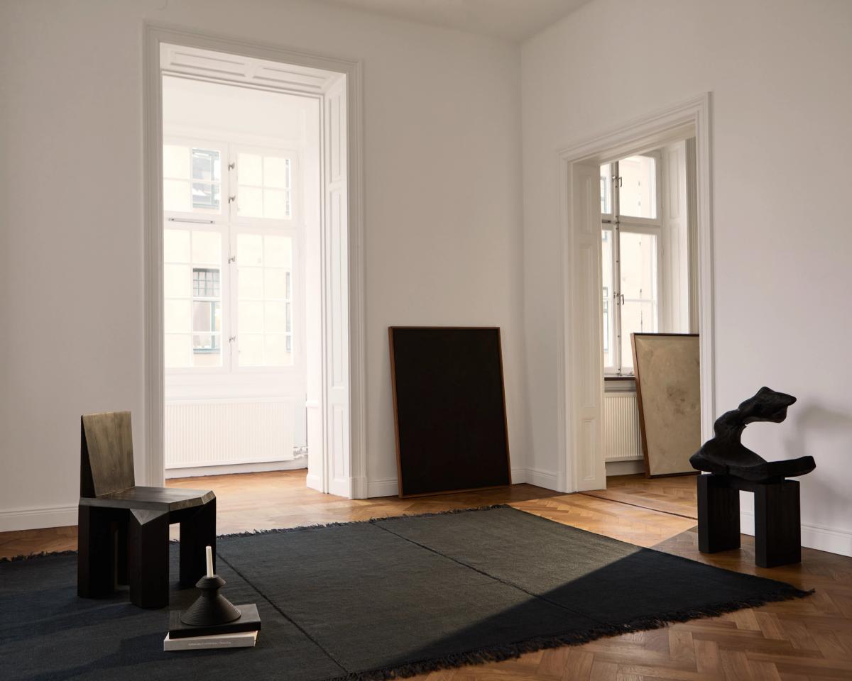 Artisan – Almost Black introduces a bold, tactile presence to this minimal setting. Handwoven with raw edges and tonal depth, it anchors sculptural furniture and soft natural light with quiet intensity.