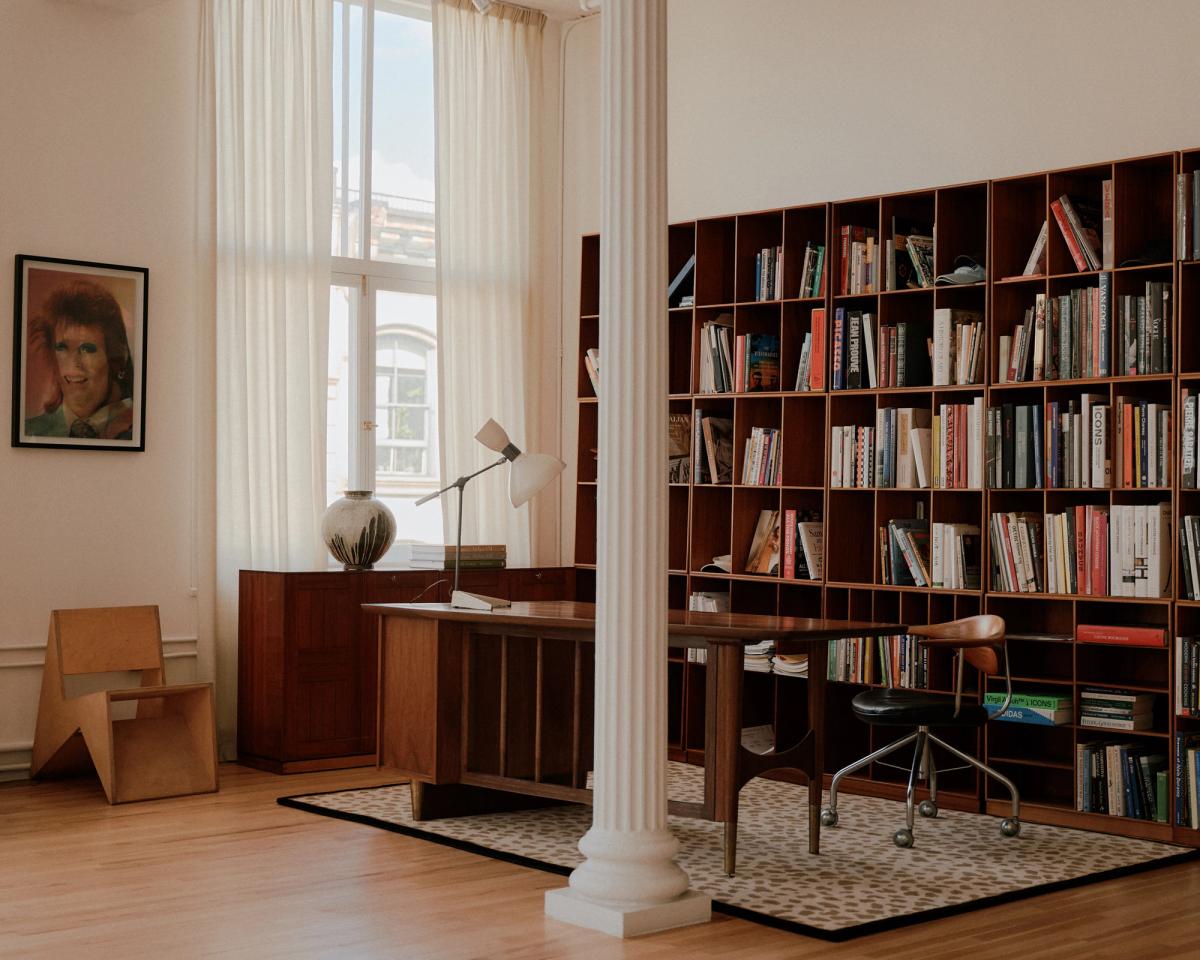 Den mjuka ullmattan Gild 03 visas i ett kontor med ett skrivbord i trä och en bokhylla.