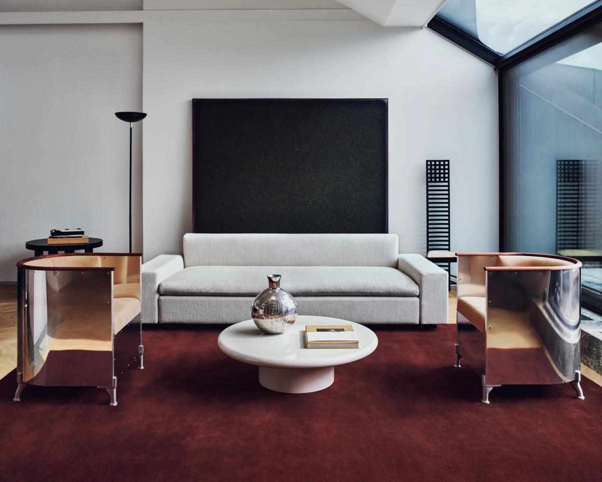 Tapis en laine moelleux Grand en coloris Deep Wine photographié dans le salon d’un appartement à Stockholm avec des fauteuils en chrome et un canapé gris.